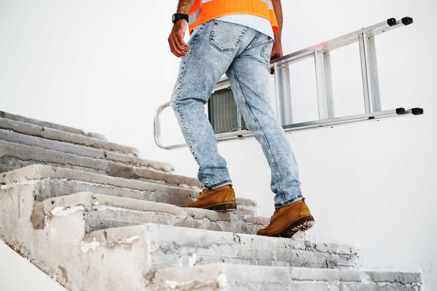técnico trabajador trepando escaleras con escalera en mano para mantenimiento con chaleco retro-reflectivo